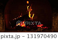 Cozy fireplace burning logs in a brick hearth during the evening hours creating a warm atmosphere for relaxation 131970490