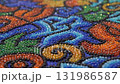 An extreme close-up, macro shot of a brightly coloured piece of intricate beadwork or mosaic, consistent with traditional Huichol art from Mexico. 131986587