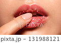 An extreme macro close-up video of a woman's lower face and lips demonstrating a lip care routine 131988121