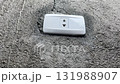 A smoking electrical outlet on a gray concrete wall from overvoltage, short circuit cause of fire 131988907