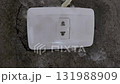 A smoking electrical outlet on a gray concrete wall from overvoltage, short circuit cause of fire 131988909