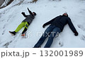 The father showed his son how to make snow angels on the fresh, white snow. 132001989