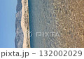 Clear blue sea with distant mountains under bright sky, perfect for travel and vacation background video 132002029