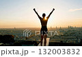 Triumphant runner celebrating at sunrise overlooking paris cityscape 132003832