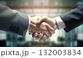 Close-up of a firm handshake between business professionals against an office backdrop 132003834