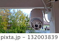 Surveillance camera rotating to monitor outdoor environment with trees in background 132003839