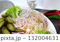 Close up of assorted pickled tomatoes cucumbers and sauerkraut with red onion served white plate in elegant restaurant style representing healthy homemade snacks rich in flavor and natural probiotics. 132004631
