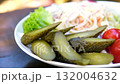 Assorted traditional pickled vegetables on white plate including salted cucumbers tomatoes and sauerkraut served in restaurant style showing healthy natural probiotic Ukrainian 132004632