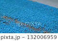 Blue recycled plastic granules on shale shaker, conveyor belt: close up 132006959