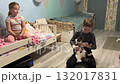 Little girl and boy having a fun time with a playful kitten on the sofa at home 132017831