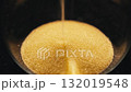 Close-up photograph of golden glittering sand leaking out of an hourglass. 132019548