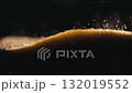 Close-up photograph of golden glittering sand leaking out of an hourglass. 132019552