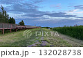 A serene, wide-angle outdoor video of a tranquil coastal or lakeside walkway in Parnu, Estonia, captured during the evening dusk. 132028738