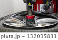 Mechanic replacing a rubber tire on the rim by hand after removal with a tire changing machine. Manual stage of seasonal tire replacement during winter preparation. 132035831
