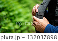 A person holding a backpack in their hand 132037898