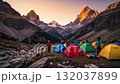 A group of people standing around tents in the mountains 132037899