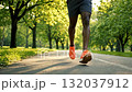 A person walking down a path in a park with orange shoes 132037912