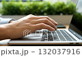 A person typing on a laptop computer on a desk 132037916