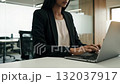 A woman sitting at a desk using a laptop computer 132037917