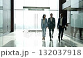 A group of three business people walking down a hallway 132037918
