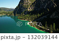 Aerial drone view of turquoise mountain lake with pine shoreline and rocky cliffs 132039144