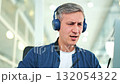 Professional Man in Headphones Thinking at Office Desk 132054322
