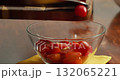 A chef cuts cherry tomatoes. Cook cutting cherry tomatoes for spaghetti with Salmon and Spinach in Creamy Sauce on wooden board with kitchen knife. 132065221