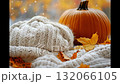 Cozy autumn setting with warm sweater, pumpkin, and falling leaves in a tranquil atmosphere 132066105