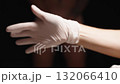 Female Doctor's Hands Putting on White Latex Gloves in Front of a Naked Man Covering Himself with His Hands. Concept of Examination. 132066410
