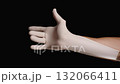 A Hand on a Black Background Puts on a White Latex Glove, Stretching It. 132066411