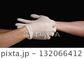 A Doctor's Assistant Removes a White Glove from the Doctor's Hand. Concept of Assistance During Surgery. Isolated on Black Background. 132066412