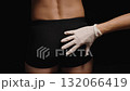 Female Doctor's Hand in a Glove Examines a Man in Black Underwear, Squeezing His Buttocks. 132066419