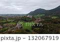 Drone footage of Schloss Hohenaschau under cloudy sky. Nebel im Tal, Kampenwand und Laubenstein Berge umgeben das Schloss im Chiemgau.  132067919