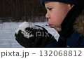 The guy blows away the snow that he picked up in his palm.  132068812