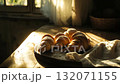 Freshly baked croissants on a rustic wooden table, morning light streaming in through the window, golden crusts glistening, soft shadows, cozy kitchen mood	 132071155