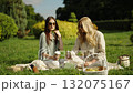 Friends enjoy a sunny picnic in the park 132075167