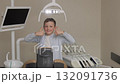 Happy boy looking at camera smiling while sitting in dentistry after teeth examination 132091736