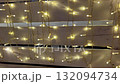 Glowing string lights illuminate decorative wooden wall display in warm festive 132094734