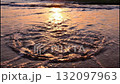 Sand art of a spiral shell revealed by ocean waves on a beach. Intricate drawing in the sand during a golden sunset. Creativity and nature concept 132097963