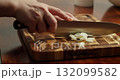 Fresh green onions large cut into rings on wooden cutting board over wooden table. Close-up 4K: Chef chopping fresh green onions, parsley and dill on wooden cutting board placed on rustic wooden table 132099582