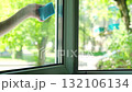 A woman's hand with a blue sponge washes an open window, copy space 132106134