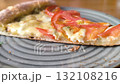 a piece of delicious and juicy pizza lies on a plate 132108216