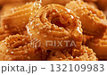 An extreme close-up, mouth-watering video of a stack of golden-brown Chebakia pastries, a traditional Maghrebi sweet. 132109983