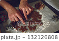 A close-up shot of hands carefully cutting homemade gingerbread cookie dough into festive shapes. Perfect for holiday baking, showing the sweet process of creating delicious treats in the kitchen. 132126808