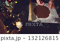 Experience the joy of baking homemade gingerbread cookies for Christmas. Hands meticulously prepare the festive dough, cutting out delicious treats amidst twinkling lights and holiday cheer. A perfect 132126815