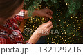 Decorating Christmas Tree with Lights and Ornaments 132129716