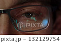 close-up of a trader eye with financial graphs reflecting in his eyeglasses 132129754
