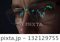Stock market charts reflecting in traders glasses while he analyzing cryptocurrency market in dark room 132129755