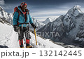 Mountain climber with backpack and ice axe standing on snowy peak enjoying scenic landscape 132142445