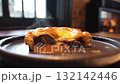 Hot delicious meat pie with melted cheese and gravy steaming on dark plate in cozy restaurant 132142446
